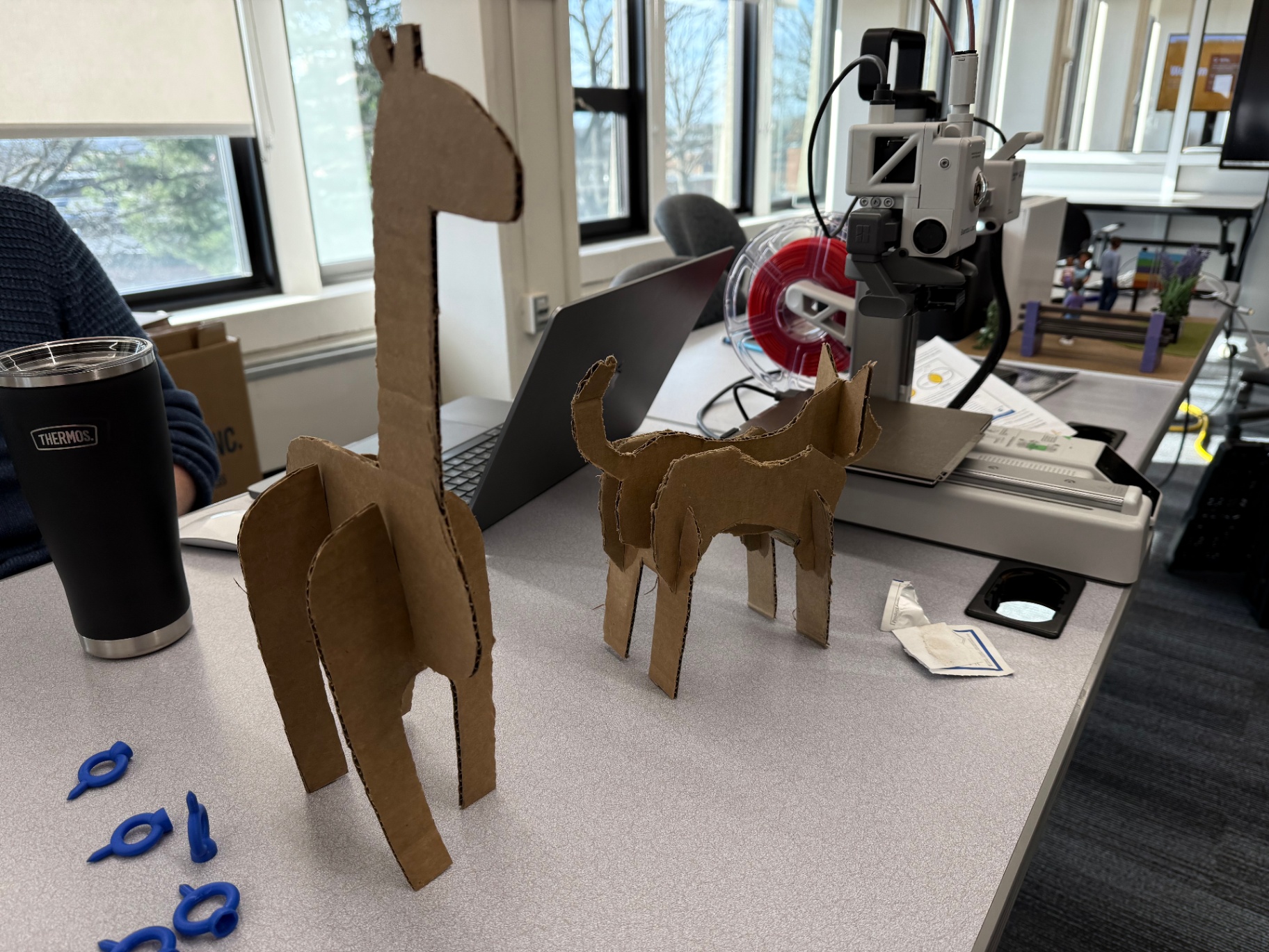 Cardboard giraffe and dog figures cut and assembled by students